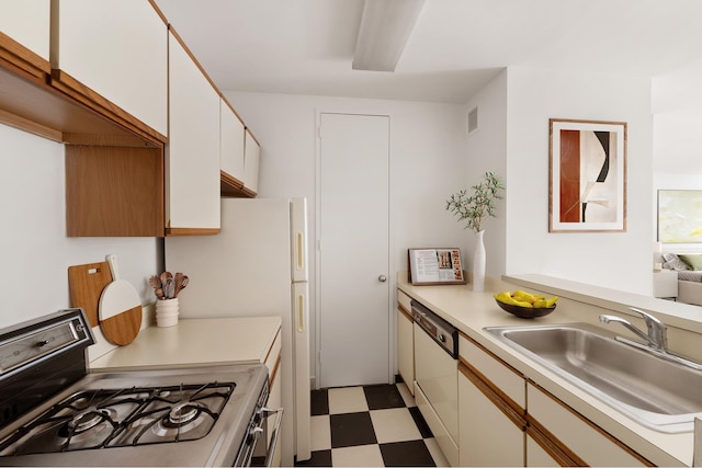 5 E 22nd St Unit 9R, New York City, NY 10010 - kitchen with gas range oven, tile patterned floors, light countertops, visible vents, and white dishwasher