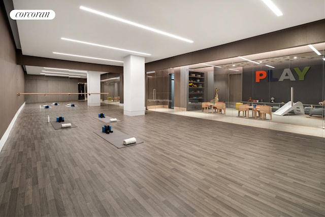 workout area with visible vents, baseboards, and wood finished floors