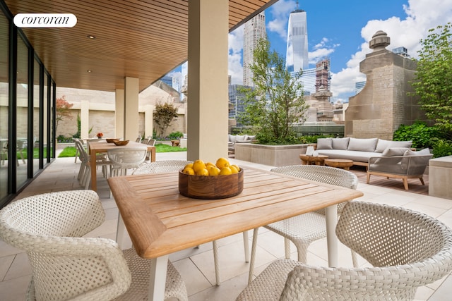 balcony featuring an outdoor living space, a patio, and a city view