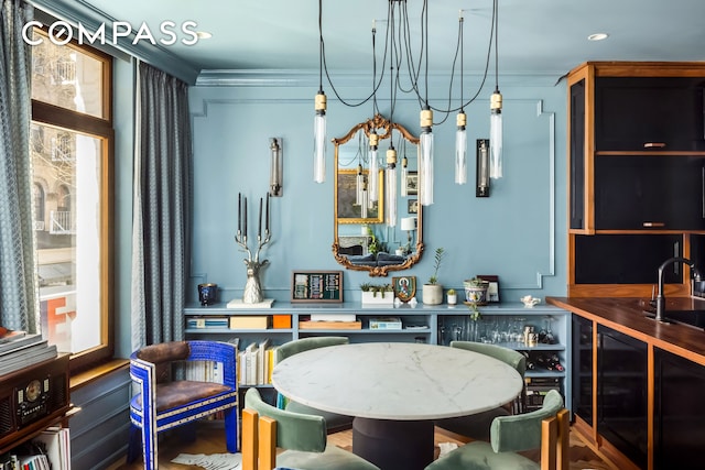 interior space featuring ornamental molding, a chandelier, and beverage cooler