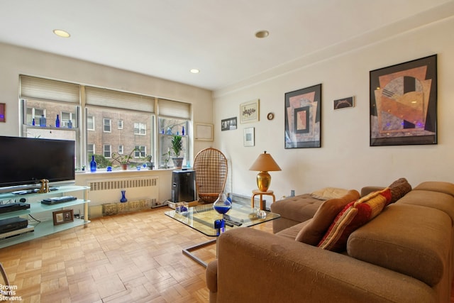 living area with radiator heating unit and recessed lighting