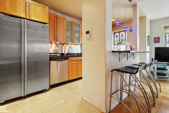 3850 Hudson Manor Ter Unit 1Ee/2Ee, New York City, NY 10463 - kitchen featuring appliances with stainless steel finishes, glass insert cabinets, dark countertops, baseboards, and a breakfast bar area