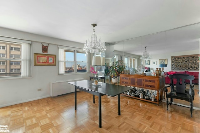 dining room with an inviting chandelier, baseboards, radiator heating unit, and a wealth of natural light