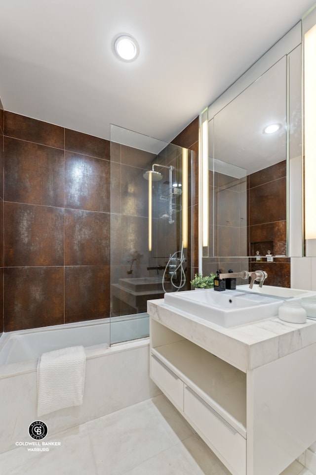 bathroom with a bath, tile walls, a tile shower, vanity, and tile patterned floors