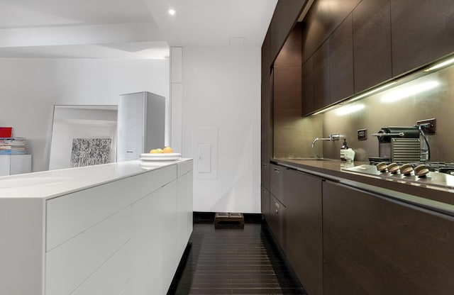 20 Pine St Unit 516, New York City, NY 10005 - kitchen featuring a sink, modern cabinets, stainless steel gas cooktop, light countertops, and white cabinets