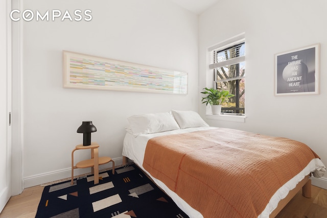 bedroom with wood finished floors and baseboards