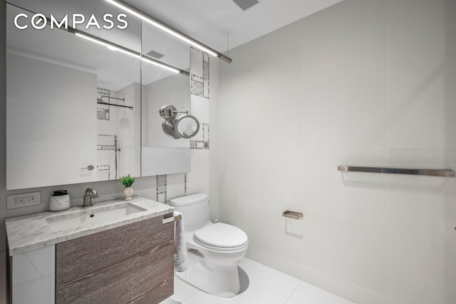 bathroom with visible vents, tile walls, tile patterned flooring, vanity, and toilet