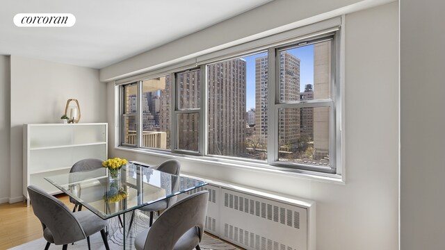 100 W 93rd St Unit 8K, New York City, NY 10025 - dining room featuring radiator, wood finished floors, and a city view