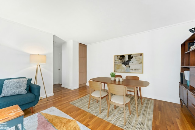 dining area with baseboards and wood finished floors