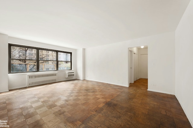 165 W End Ave Unit 2J, New York City, NY 10023 - empty room with radiator, a wall mounted AC, and baseboards