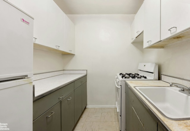 165 W End Ave Unit 2J, New York City, NY 10023 - kitchen featuring white appliances, a sink, white cabinetry, and light countertops