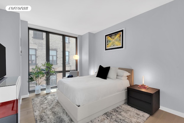 4 W 21st St Unit 4B, New York City, NY 10010 - bedroom featuring expansive windows, baseboards, light wood finished floors, and access to outside