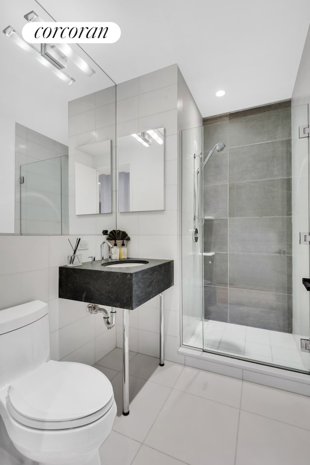 4 W 21st St Unit 4B, New York City, NY 10010 - bathroom with toilet, a stall shower, a sink, tile patterned floors, and tile walls