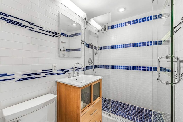 55 E End Ave Unit 12Hj, New York City, NY 10028 - full bathroom featuring toilet, tile walls, a stall shower, and vanity