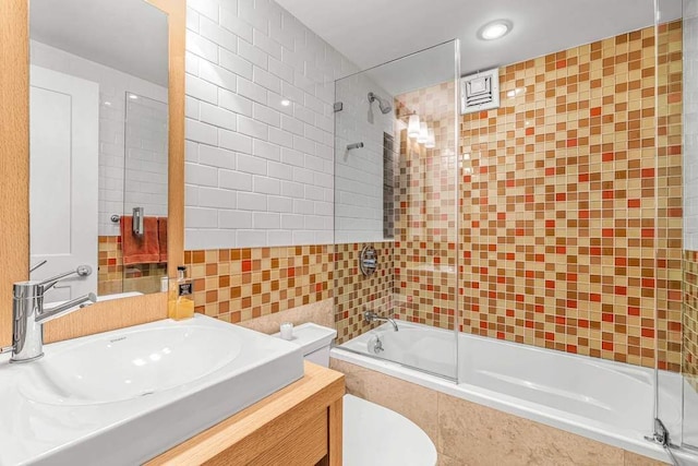 55 E End Ave Unit 12Hj, New York City, NY 10028 - full bath featuring toilet, tiled shower / bath, vanity, and tile walls
