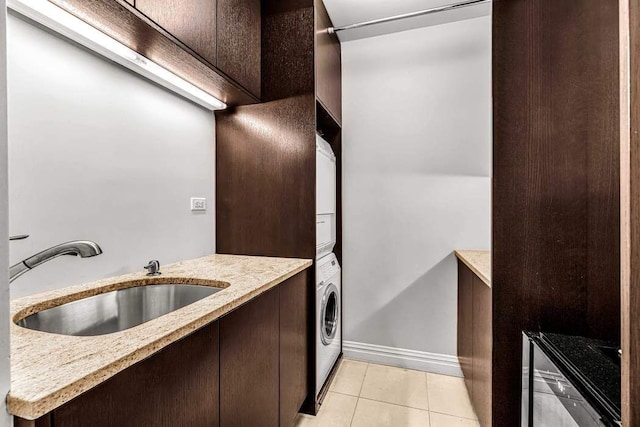 55 E End Ave Unit 12Hj, New York City, NY 10028 - laundry room with stacked washer and dryer, light tile patterned floors, baseboards, and a sink