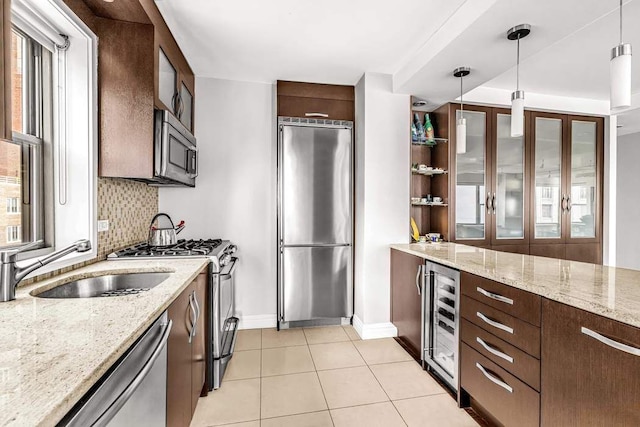 55 E End Ave Unit 12Hj, New York City, NY 10028 - kitchen featuring baseboards, light tile patterned floors, wine cooler, pendant lighting, and appliances with stainless steel finishes
