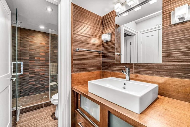 55 E End Ave Unit 12Hj, New York City, NY 10028 - bathroom featuring recessed lighting, toilet, a sink, tile walls, and a stall shower