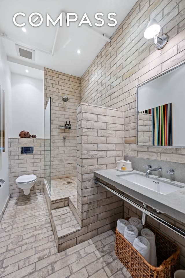 full bath featuring a sink, walk in shower, toilet, and brick floors