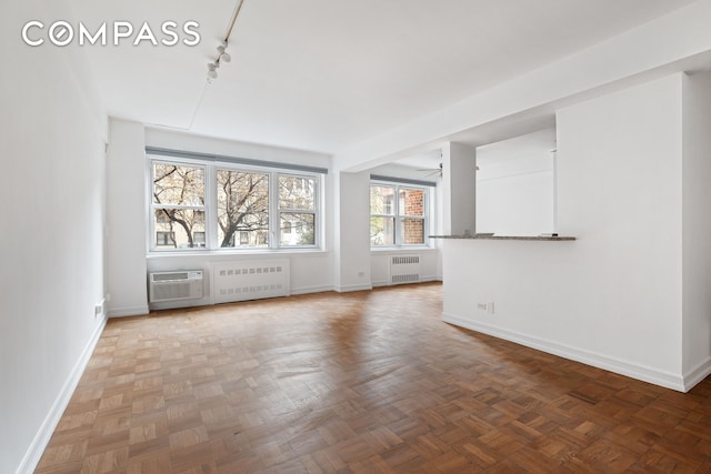 11 Riverside Dr Unit 2He, New York City, NY 10023 - unfurnished living room featuring radiator heating unit, baseboards, and rail lighting