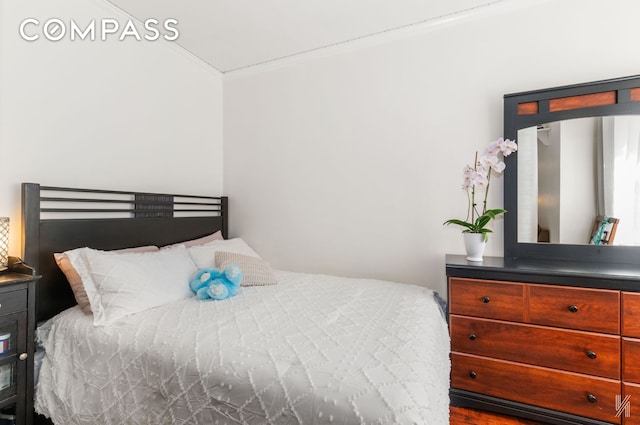 bedroom featuring arched walkways and crown molding