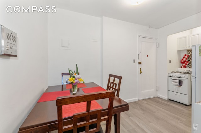 dining area featuring light wood-style flooring and baseboards