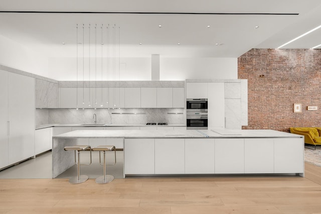 55 Walker St Ph, Ph, New York City, NY 10013 - kitchen featuring modern cabinets, white cabinetry, a sink, light wood finished floors, and a towering ceiling