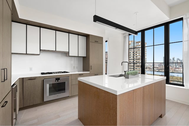 959 1st Ave Unit 25E, New York City, NY 10022 - kitchen with stainless steel appliances, light wood-style flooring, light countertops, and modern cabinets
