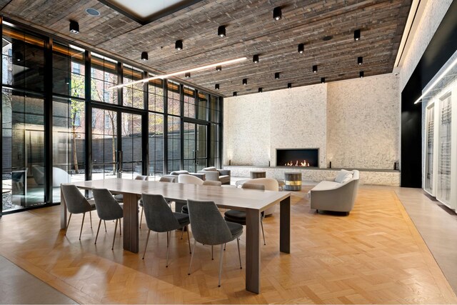 dining room with a high ceiling, floor to ceiling windows, and a fireplace