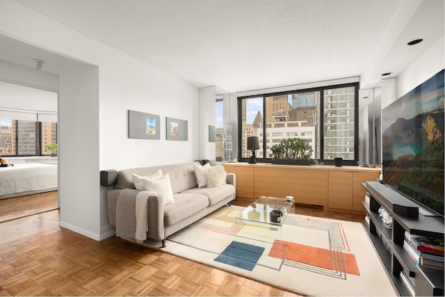 living room featuring a view of city, baseboards, and a textured ceiling