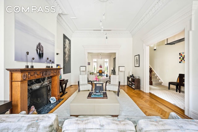 living room with stairs, a premium fireplace, baseboards, and ornamental molding