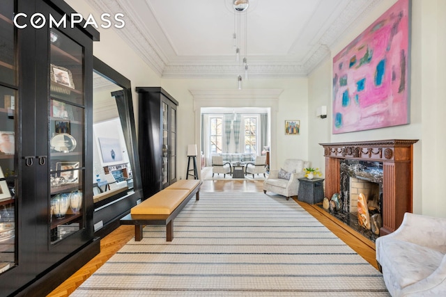 living area featuring wood finished floors and ornamental molding