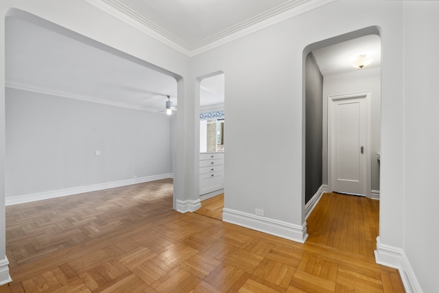 interior space with arched walkways, crown molding, and baseboards