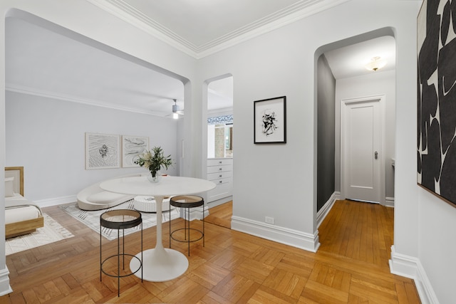 dining space with ornamental molding, baseboards, and arched walkways