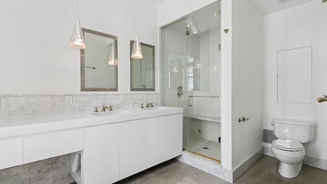 full bath featuring baseboards, toilet, vanity, and a stall shower