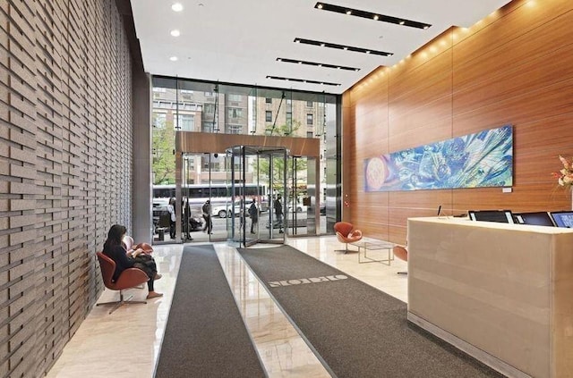 community lobby with a wall of windows, a high ceiling, and recessed lighting