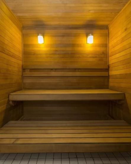 relaxing sauna featuring wood ceiling and wood walls