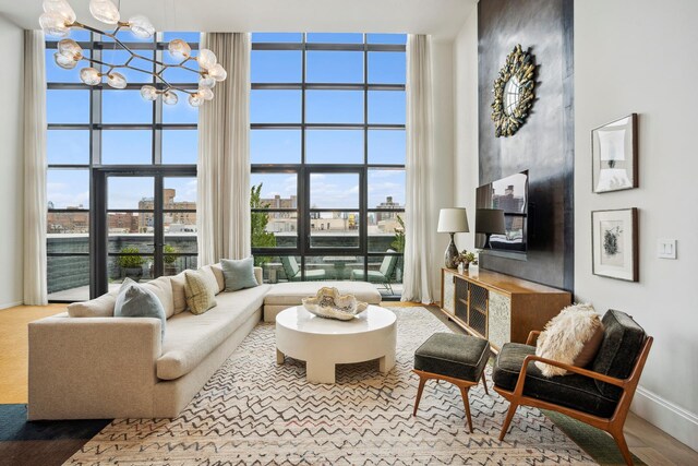 438 E 12th St Phd, Phd, New York City, NY 10009 - living area with baseboards, a notable chandelier, a city view, and a towering ceiling