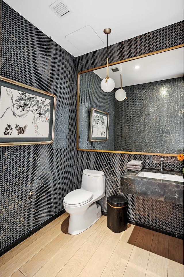 438 E 12th St Phd, Phd, New York City, NY 10009 - bathroom featuring visible vents, tile walls, wood finished floors, vanity, and toilet
