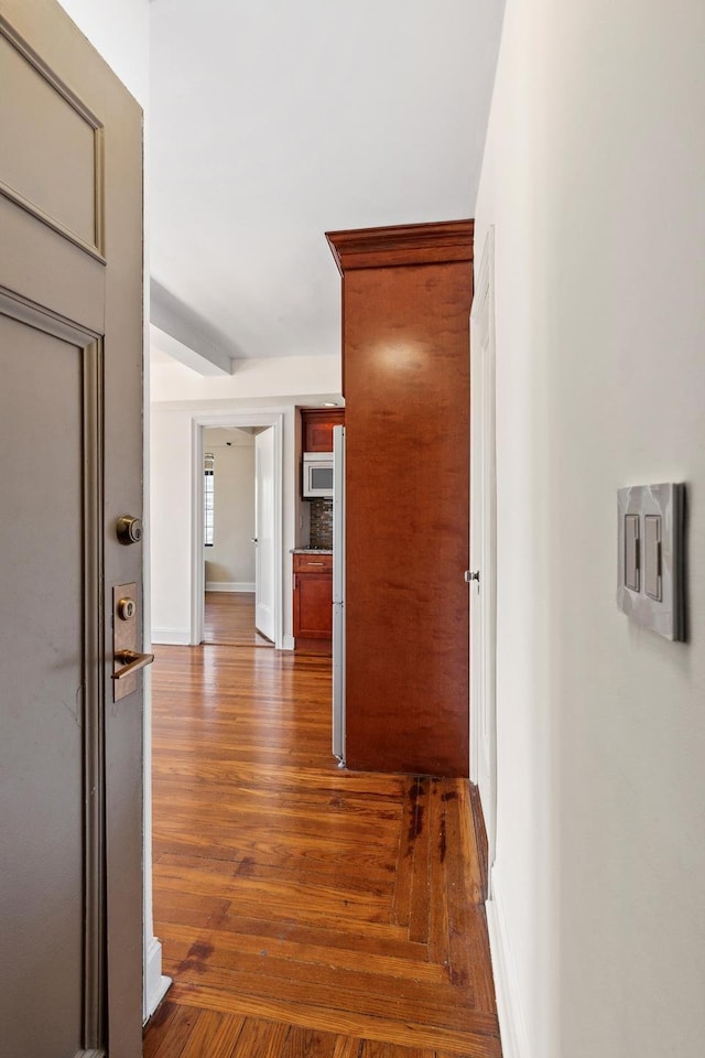hall featuring baseboards and dark wood-style floors