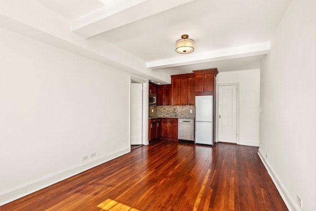 kitchen with appliances with stainless steel finishes, backsplash, dark wood-style floors, baseboards, and light countertops