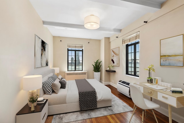 bedroom with radiator, beamed ceiling, wood finished floors, and baseboards