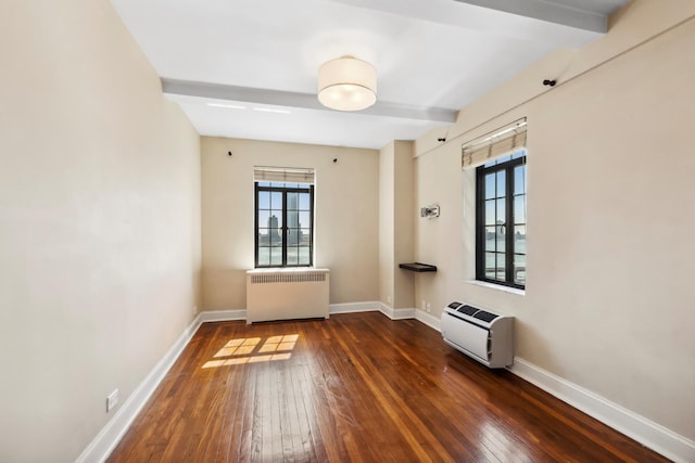 unfurnished room with radiator, hardwood / wood-style flooring, beam ceiling, baseboards, and heating unit