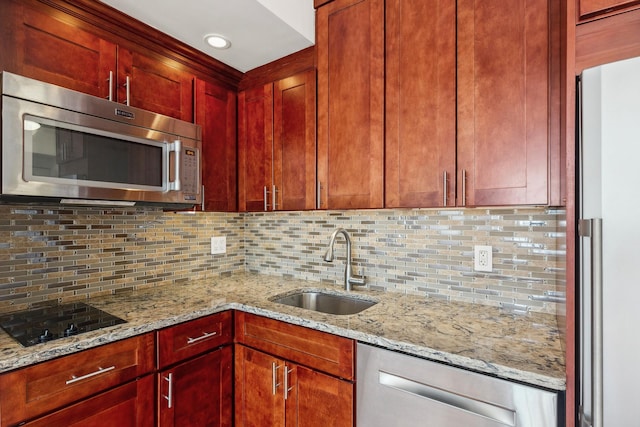 kitchen with appliances with stainless steel finishes, a sink, dark brown cabinets, decorative backsplash, and recessed lighting