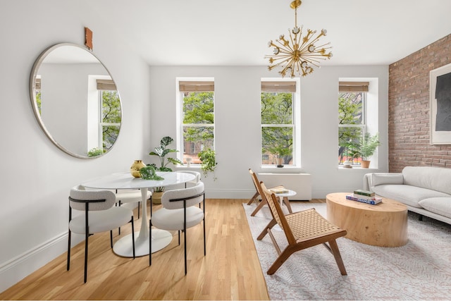 sitting room with wood finished floors, healthy amount of natural light, baseboards, and a chandelier