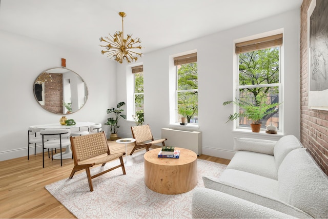 sitting room featuring light wood-type flooring, baseboards, and a chandelier