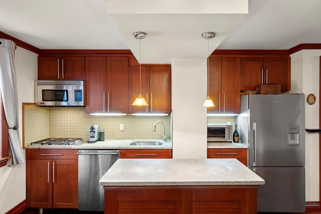 kitchen with stainless steel appliances, a sink, tasteful backsplash, pendant lighting, and light stone counters