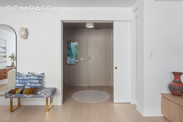 hallway featuring wood finished floors and baseboards