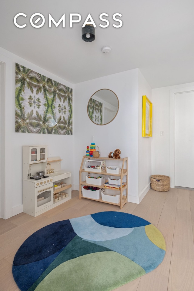 rec room featuring wood finished floors and baseboards