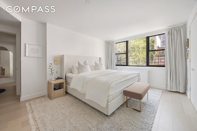 bedroom with baseboards and light wood-type flooring